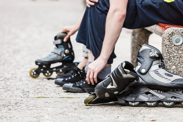 People friends putting on roller skates outdoor. - Foto, imagen