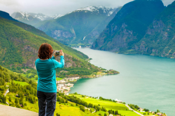 Female tourist taking photo at norwegian fjord - Fotografie, Obrázek