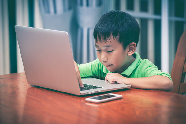 asiatischer Junge genießt moderne Technologien beim Spielen in Innenräumen - Foto, Bild