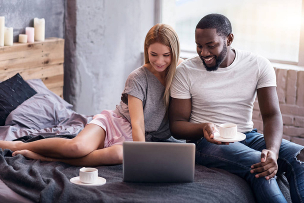 Sweet couple lying in bedroom with laptop - Photo, Image