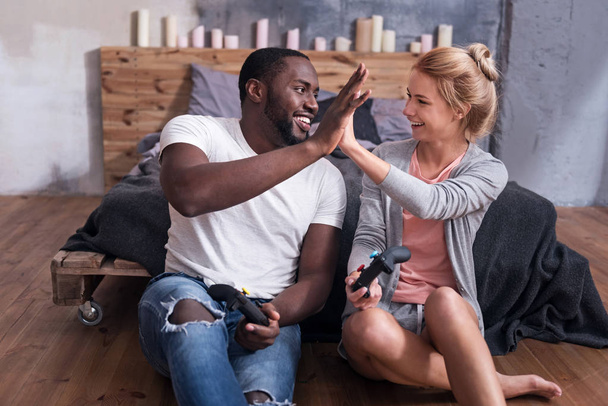 Overjoyed couple enjoying video games in their bedroom - Photo, Image
