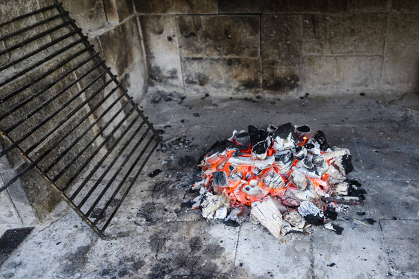 Hete barbecue iron grill en gloeiende houtskool - Foto, afbeelding