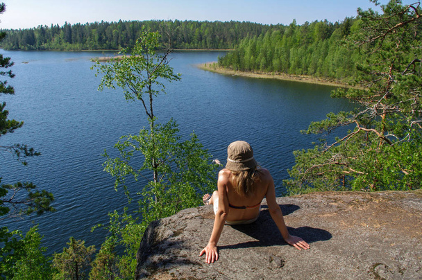 mujer disfruta de vistas al lago. Un relax en la orilla del lago con arround bosque. Supervisión del horizonte
. - Foto, Imagen