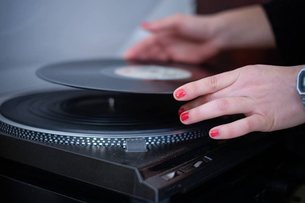 Vrouw luisteren naar muziek met behulp van vintage vinyl record - Foto, afbeelding