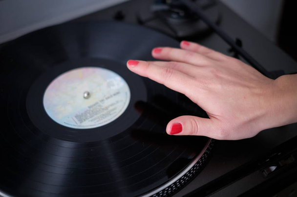 Nainen kuuntelee musiikkia käyttäen vintage vinyyli levy
 - Valokuva, kuva
