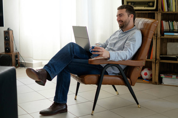 Onun laptop ve wi-fi internet connecti kullanarak evde çalışan adam - Fotoğraf, Görsel
