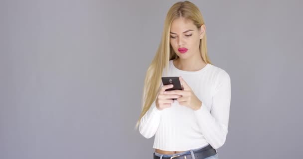 Trendy young blond woman checking her mobile - Metraje, vídeo