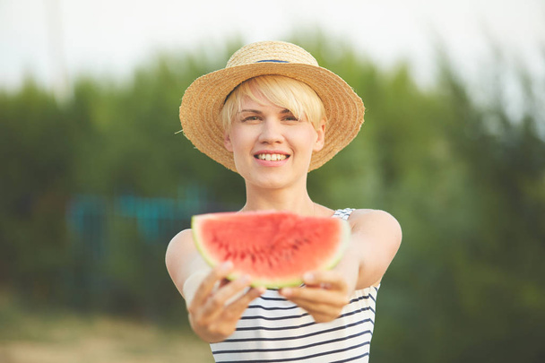 Beautiful girl in straw hat eating fresh watermelon. Film camera style - Foto, Imagen