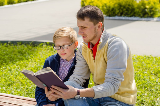 Young man is helping teenager to read a book - Foto, Imagem