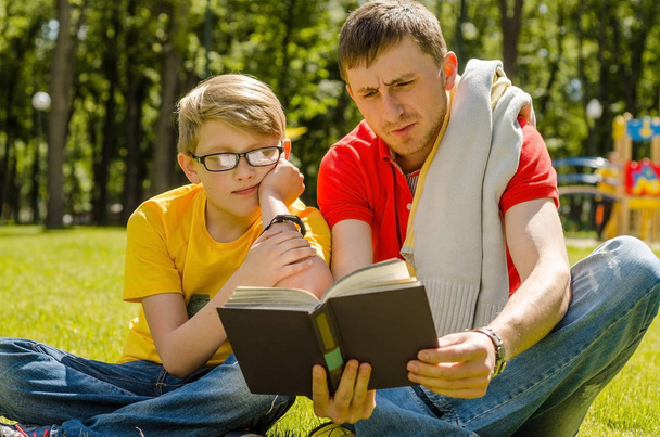 Young man is reading a book with teenager - Foto, Bild