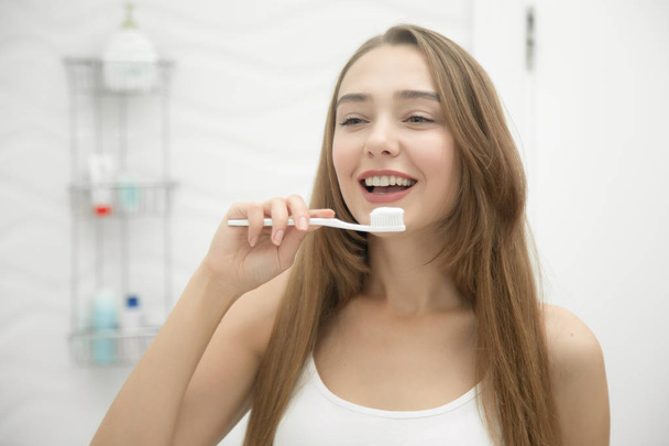 Portret van een jonge lachende meisje haar tanden reinigen - Foto, afbeelding