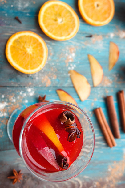 Orange, apple, cinnamon, anise, wine (mulled wine) on wooden background - Fotó, kép
