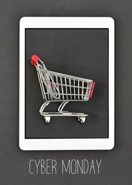 text cyber monday and shopping cart in a tablet - Photo, Image