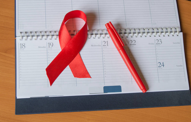 Czerwone wstążki na kalendarz, aby podnieść świadomość przeciwko Aids kopiować przestrzeń - Zdjęcie, obraz