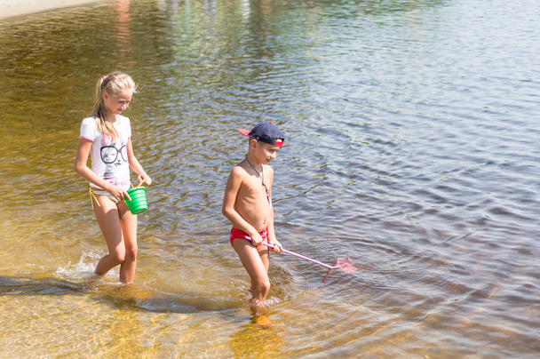Children fishing in a river with a fishing net - Foto, imagen