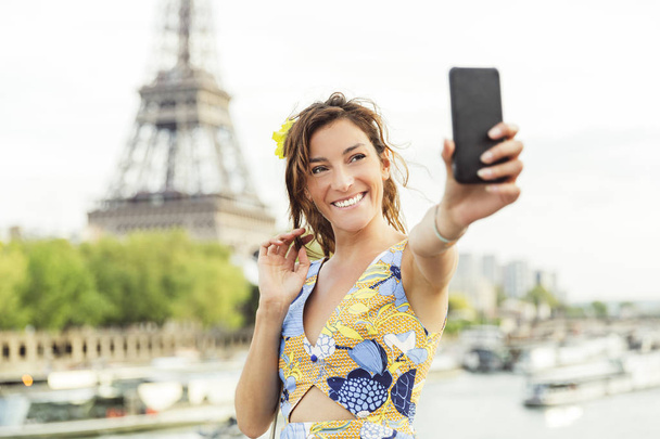 Mulher fazendo uma selfie em Paris com Torre Eiffel no fundo
 - Foto, Imagem