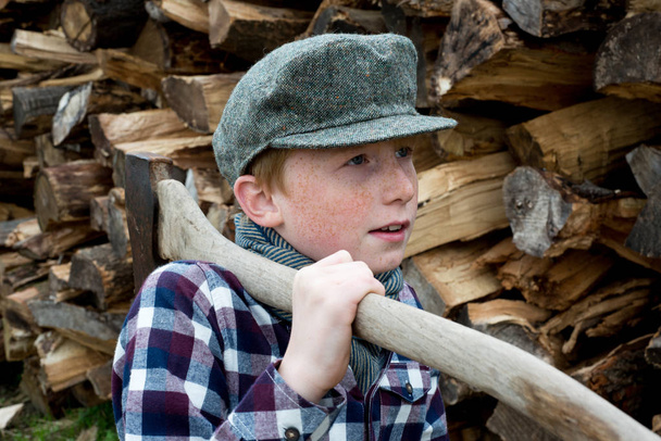 Хлопчик перед купою дров
 - Фото, зображення