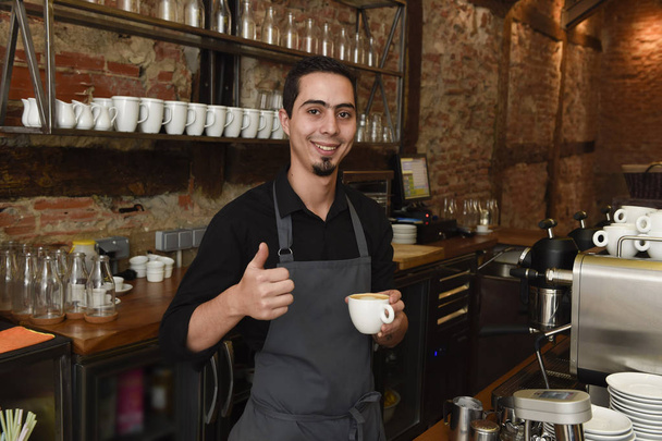 fiatal olasz barista vagy készül a tej tejszín gép café étterem boltban kávéfőző - Fotó, kép