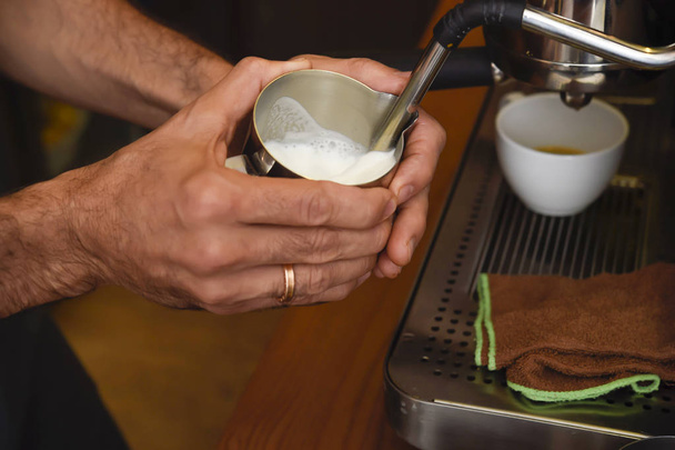 barista cerrar las manos preparando deliciosa máquina de operación de crema de café en la cafetería
 - Foto, Imagen