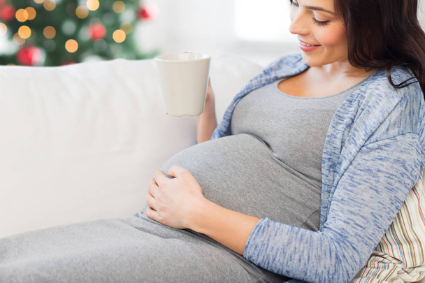 close up of pregnant woman drinking tea at home - Fotografie, Obrázek
