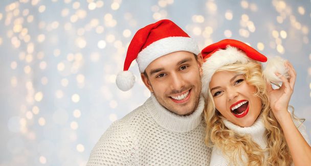 happy family couple in sweaters and santa hats - Valokuva, kuva