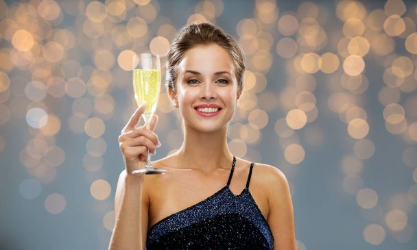 sonriente mujer sosteniendo un vaso de vino espumoso
 - Foto, Imagen