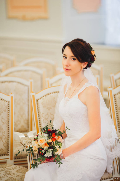 Young bride in wedding dress holding bouquet - Foto, Imagen
