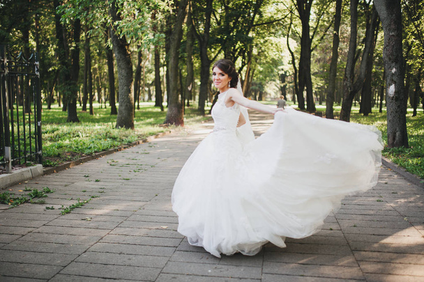 Young bride in wedding dress holding bouquet - Foto, Imagen
