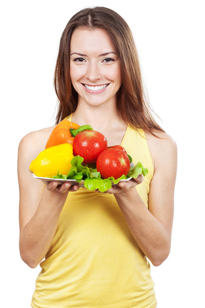 woman holding plate of fresh vegetables - Фото, изображение