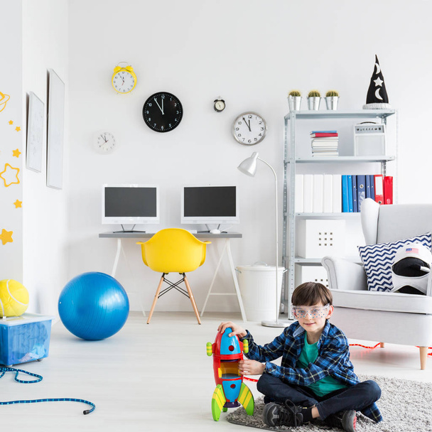 Boy is playing with toy racket in his room - Foto, Imagem