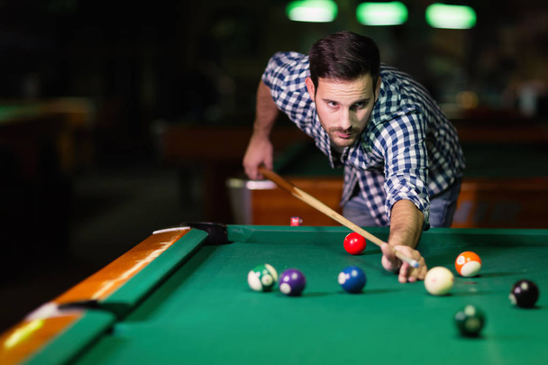 Man playing pool in pub - Фото, изображение