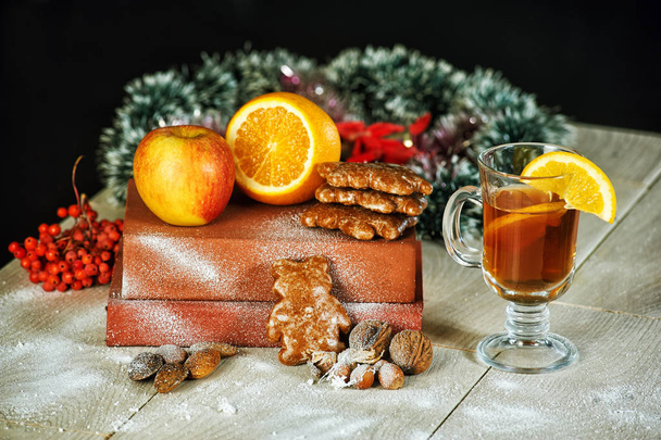 Vinho amontoado para o Natal com maçãs laranja no fundo escuro
 - Foto, Imagem