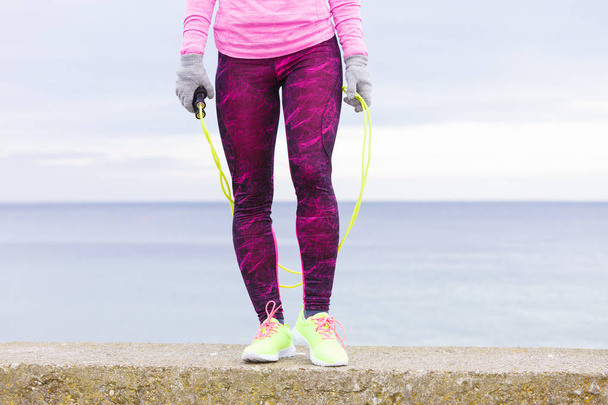 Woman training outdoor with jump rope on cold day - Fotó, kép