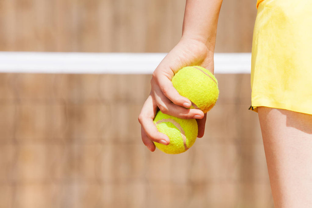 young girl holding tennis balls - 写真・画像