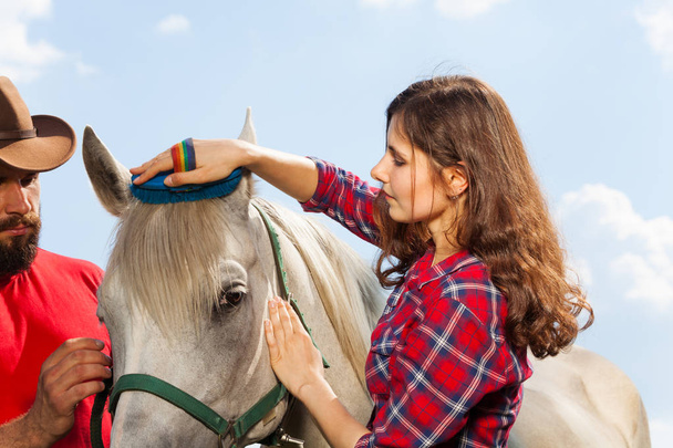 couple brushing white horse - Photo, Image