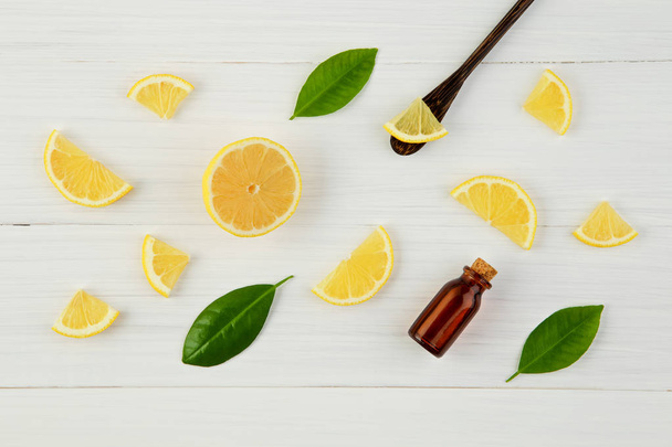 Citrons frais et feuilles à l'huile essentielle sur fond bois rustique
 - Photo, image
