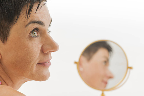 Lächeln im Gesicht einer Frau mit Spiegel - Foto, Bild