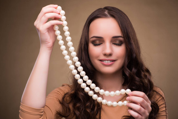 真珠のネックレスを持つ若い女性 - 写真・画像