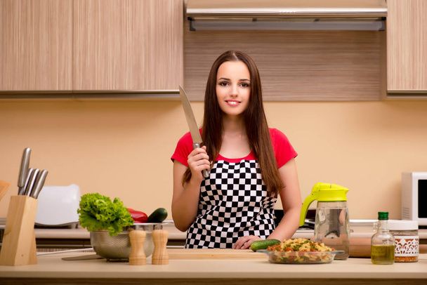 Jeune femme au foyer travaillant dans la cuisine
 - Photo, image