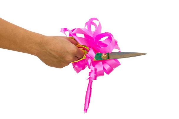 homem mão cortando algo com tesoura e arco rosa isolado no fundo branco
. - Foto, Imagem