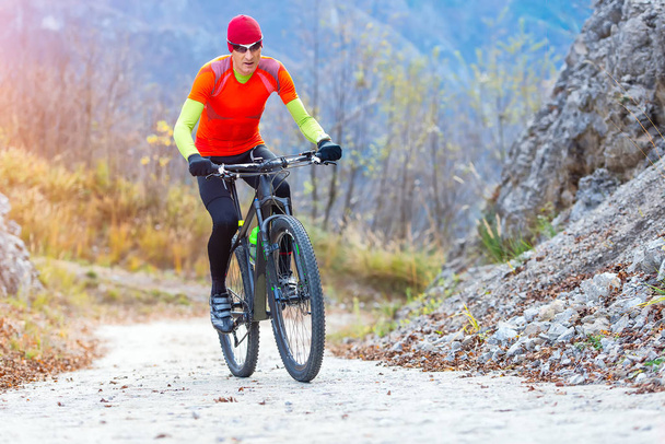 Muž horská cykloturistika do kopce jízda na konkrétní silnici - Fotografie, Obrázek