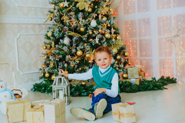 mały chłopiec przygotowania do Bożego Narodzenia w urządzonego salonu - Zdjęcie, obraz