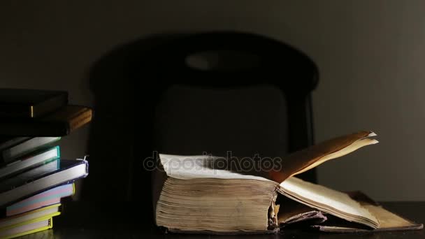 Inteligentny człowiek studia późno w nocy, siedzi przy biurku i czytanie książki - Materiał filmowy, wideo