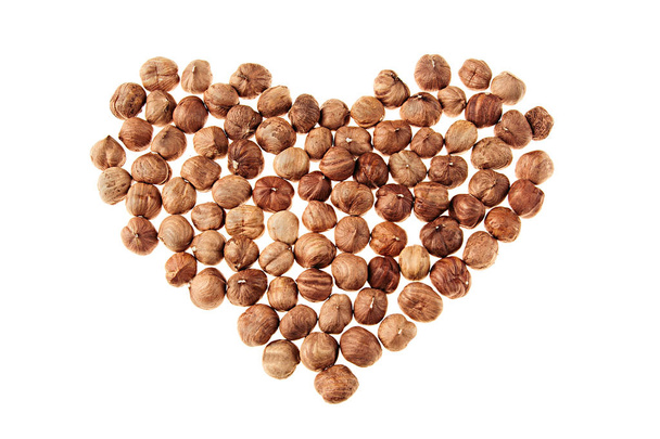 Hazelnut heap in heart shape on white background.  - Фото, зображення
