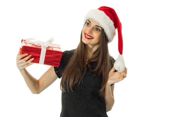 Adorable girl smiling in santa hat with red gift - Foto, imagen