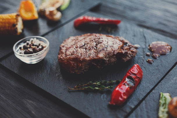 Grillezett marhahús steak Közelkép a háttér sötét fából készült asztal - Fotó, kép
