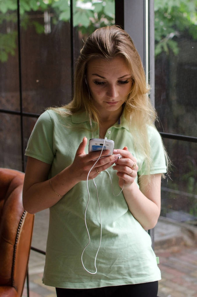 woman is listening to music in headphones - Foto, afbeelding