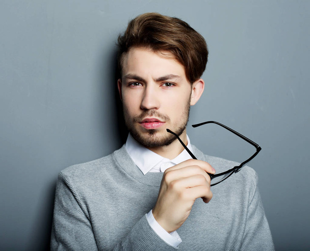 young businessman with eyeglasses, looking at the camera against - Foto, afbeelding