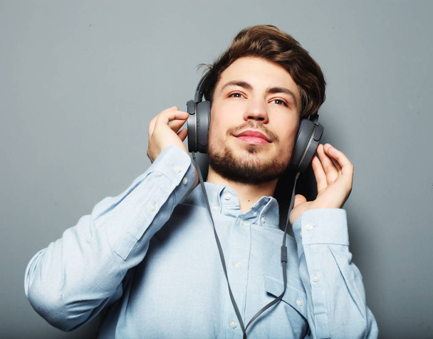 Handsome young man wearing headphones and listening to music. - Fotoğraf, Görsel
