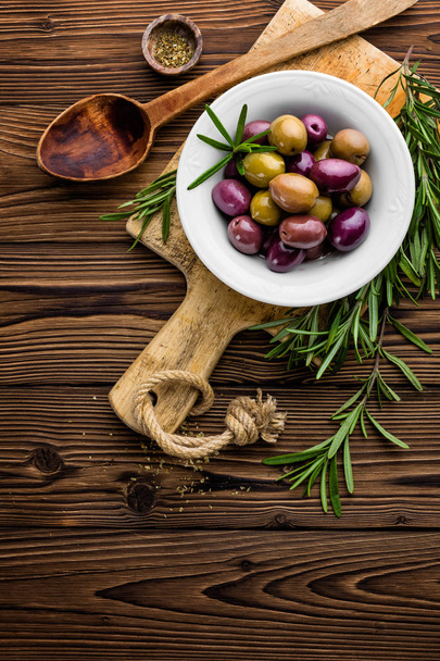 rosemary, olives, olive oil on wooden background - Fotó, kép